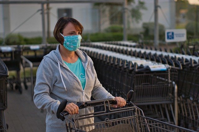 Mujer compra en supermercado con tapabocas ante la Crisis del COVID-19