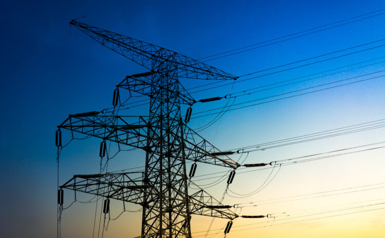 Torres de alta tensión al atardecer representando el sector de utilities, con cielo anaranjado y estructuras metálicas que simbolizan la infraestructura crítica donde se aplica la gobernanza de datos.