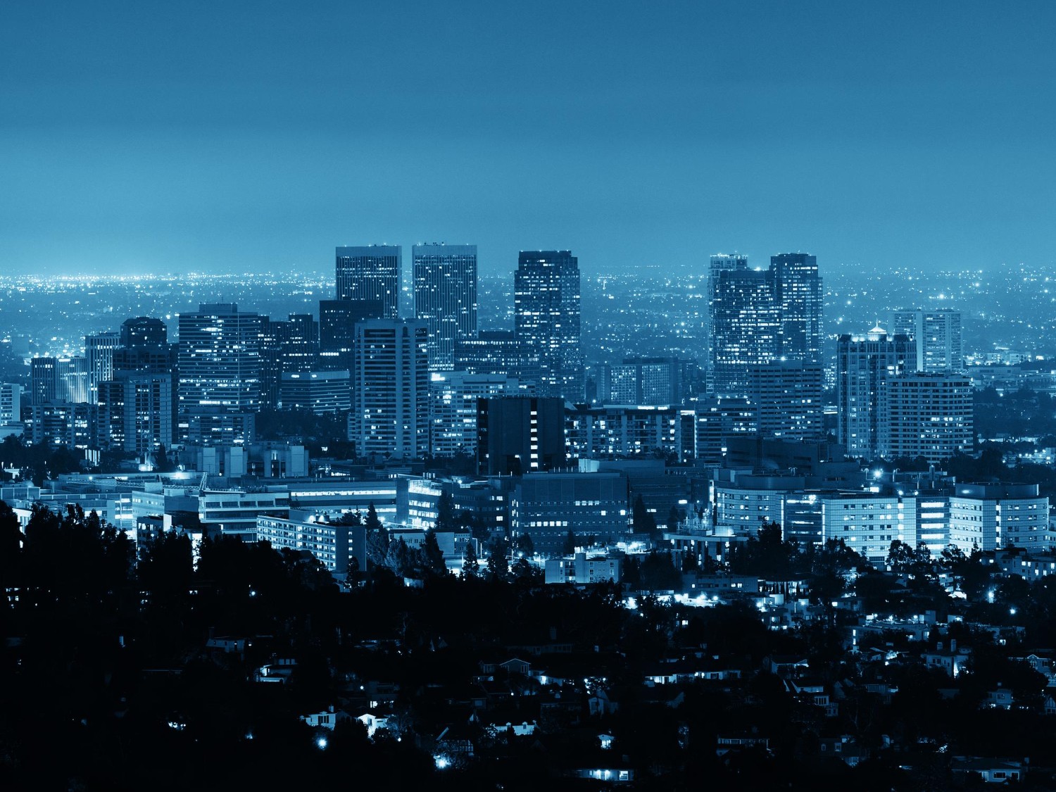 Vista nocturna de una ciudad densamente iluminada, representando la alta demanda de energía que se gestiona mediante el pronóstico de carga para optimizar costos y ganar eficiencia en el sistema eléctrico