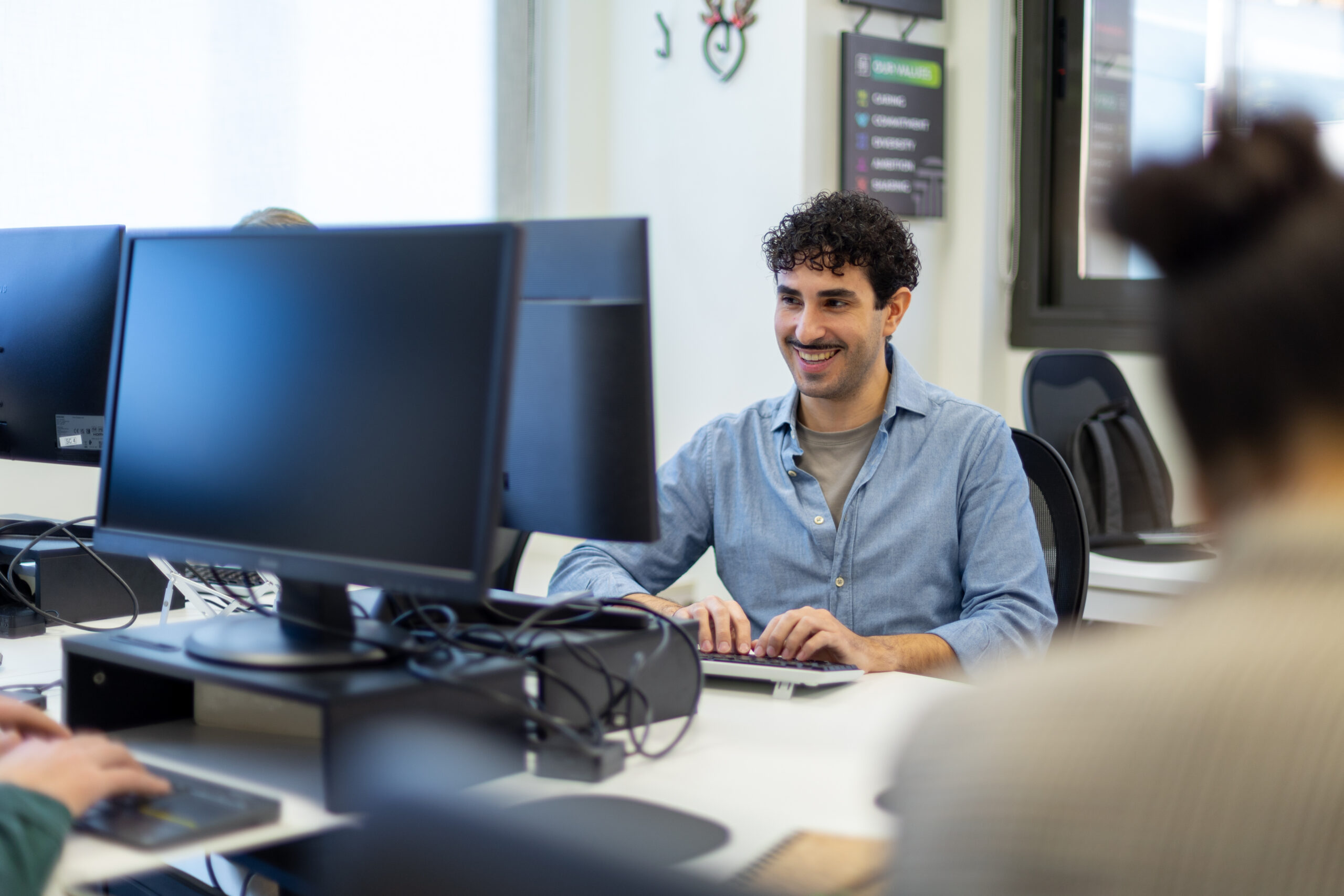 Profesional en una oficina moderna utilizando herramientas de vibe-coding para agilizar el desarrollo de aplicaciones y prototipos funcionales con IA.